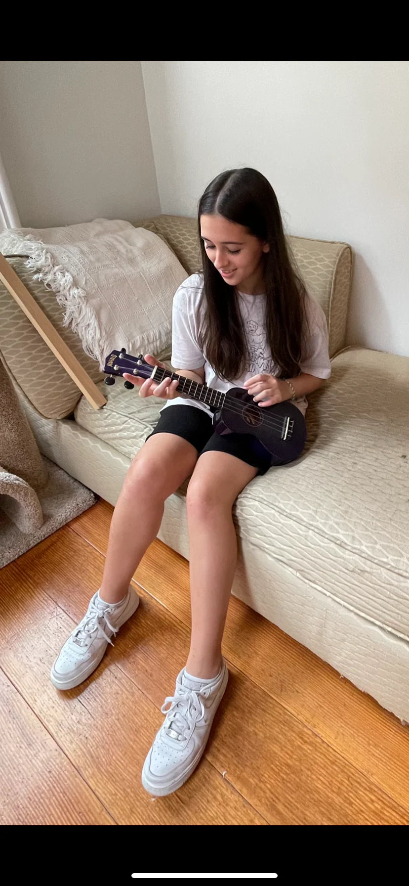 Teen in sneakers sitting on a couch